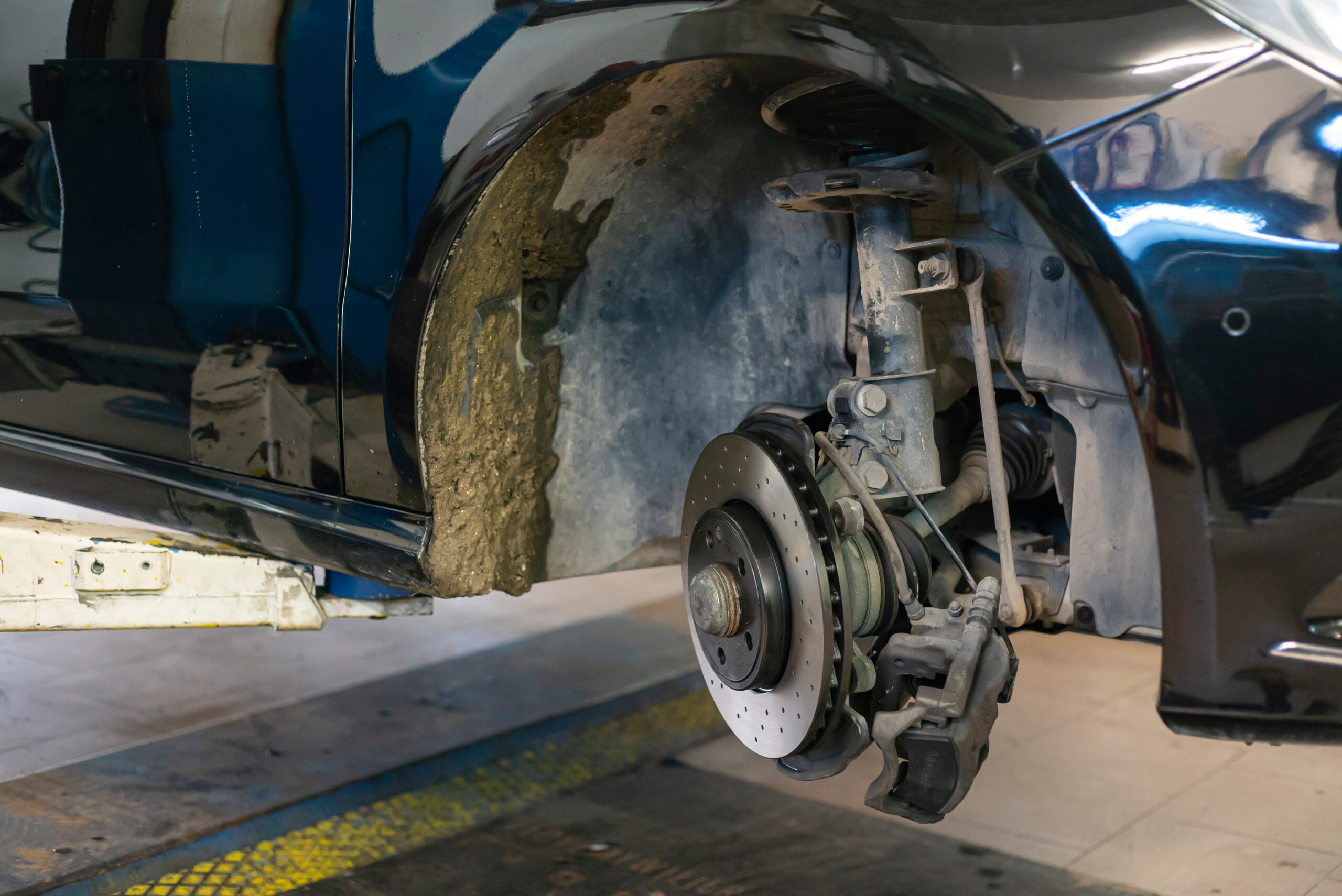 Mechanic inspecting car brake disc and caliper