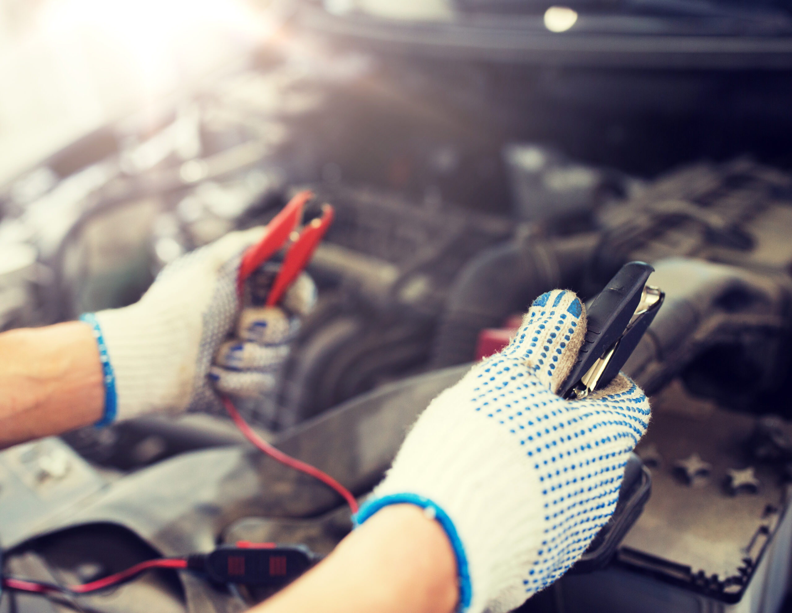 Mechanic testing and replacing a car battery