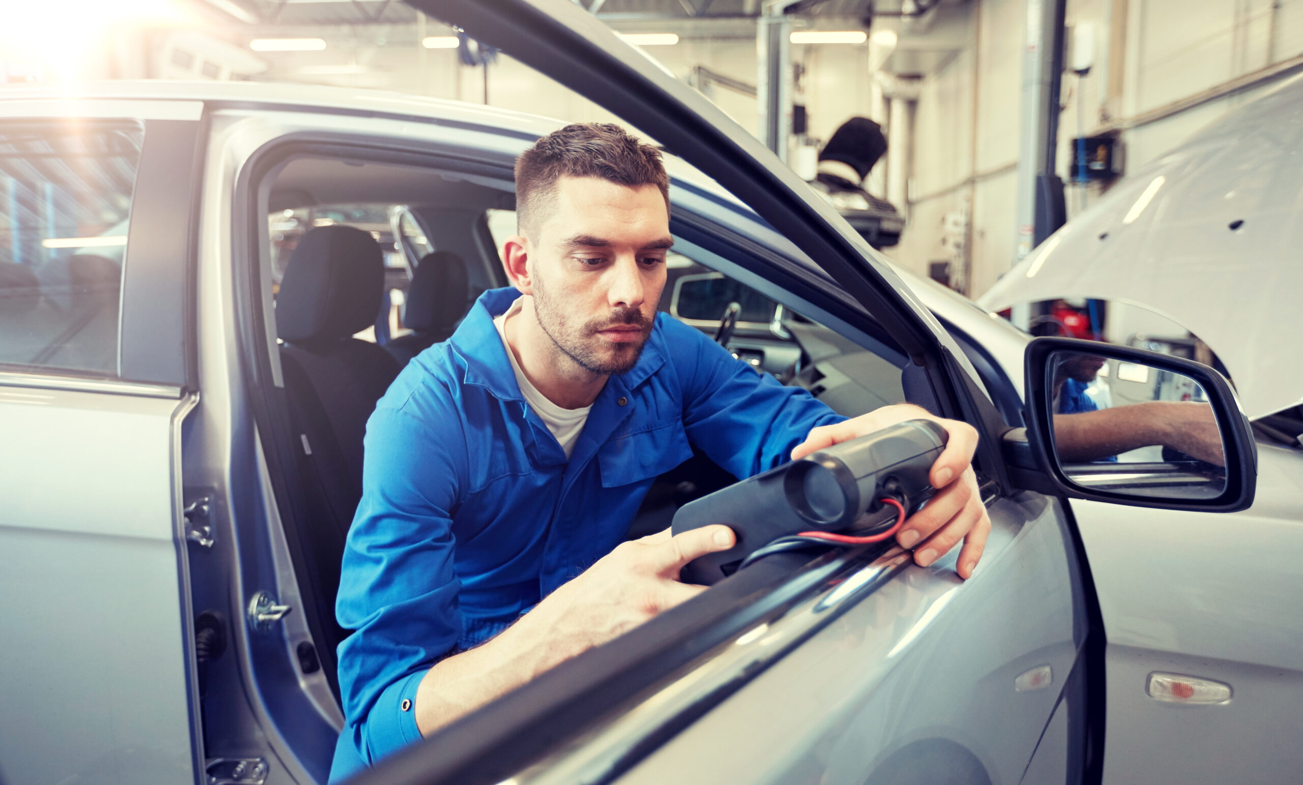 Mechanic performing engine diagnostics on a vehicle
