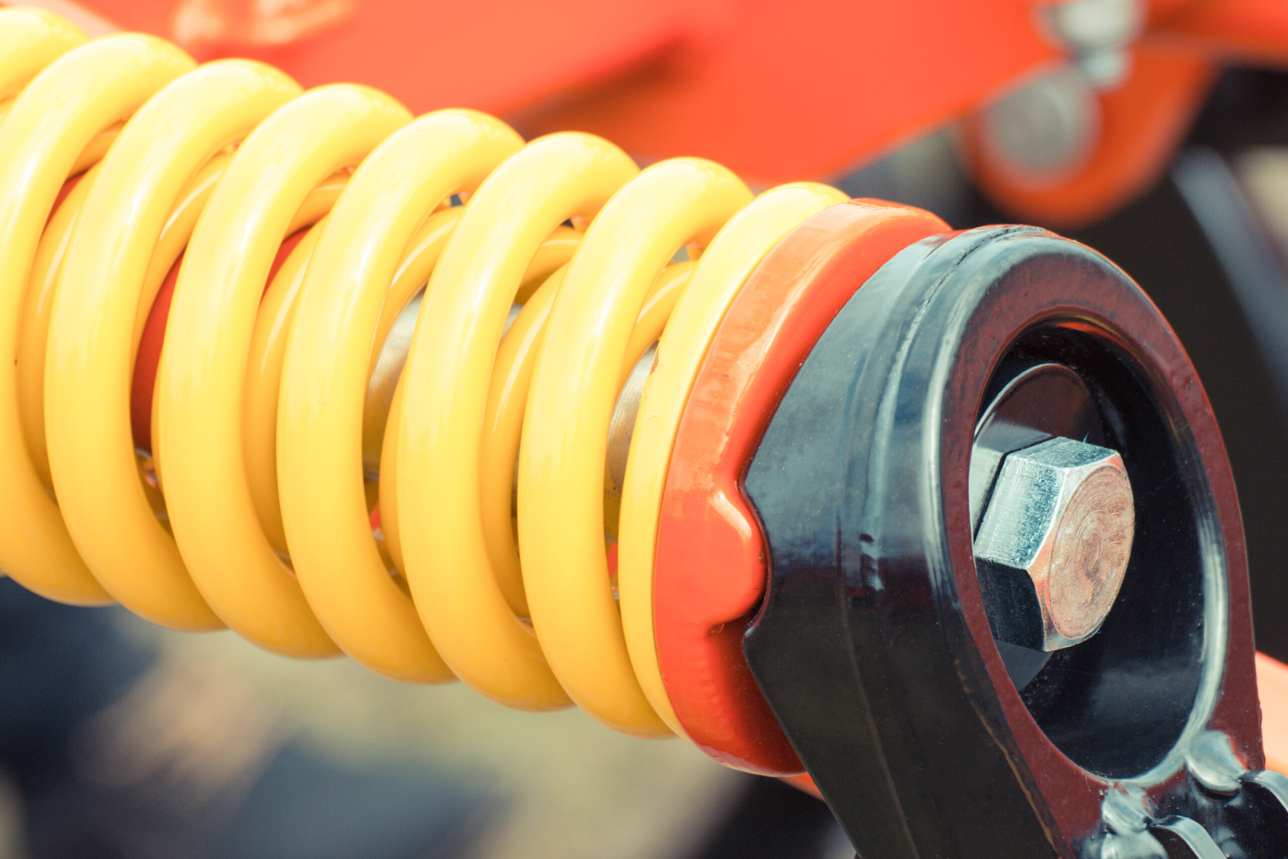 Mechanic inspecting car suspension coil spring