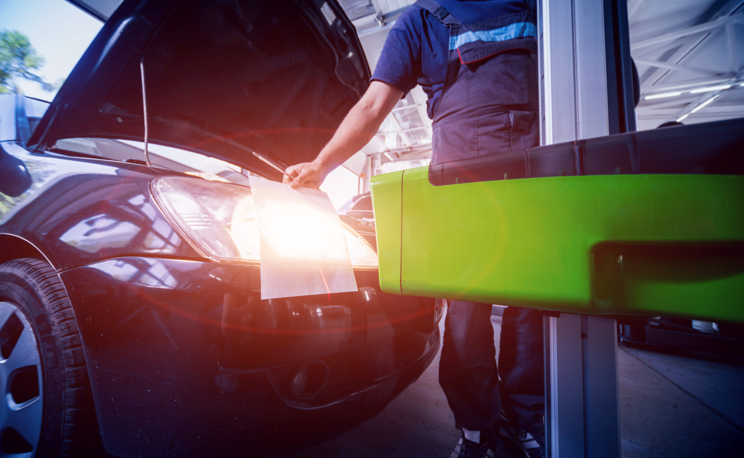 Mechanic inspecting car headlight lighting system